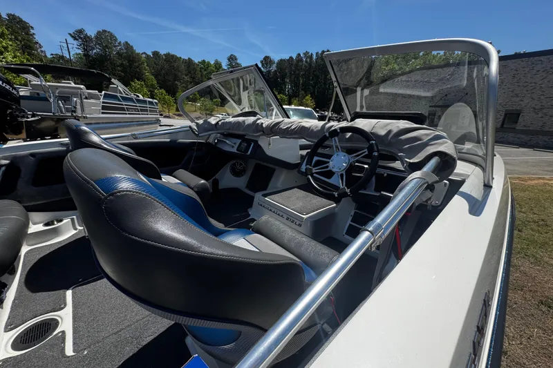 Slide: The Image of 2018 Ranger 212LS Reata boat interior with steering wheel and seating under clear blue sky. - 9