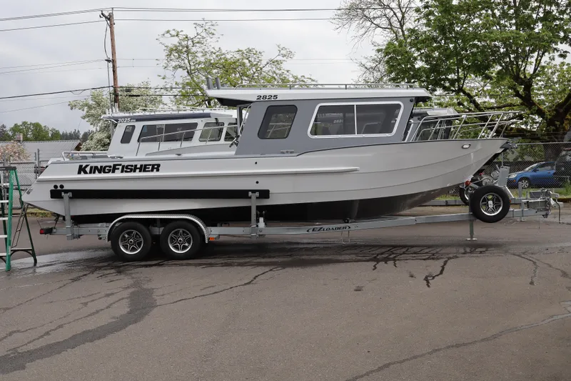 The Image of 2026 KingFisher 2825 Coastal Express boat on trailer, parked outdoors. - 1