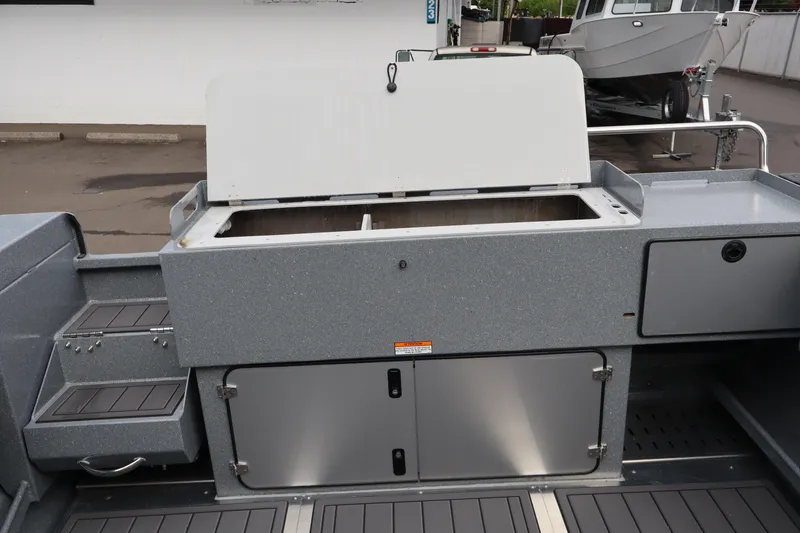 Slide: The Image of 2026 KingFisher 2825 Coastal Express boat interior with storage compartments and open hatch. - 6