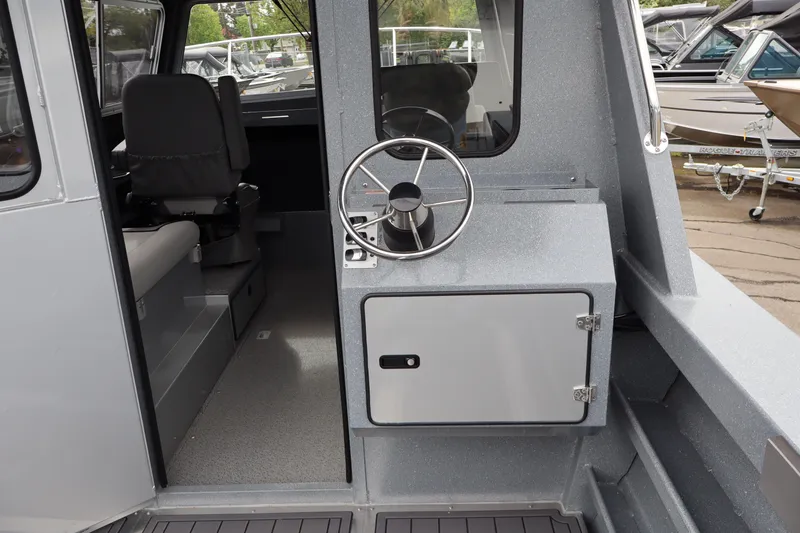 Slide: The Image of 2026 KingFisher 2825 Coastal Express boat interior with steering wheel and seating area. - 8