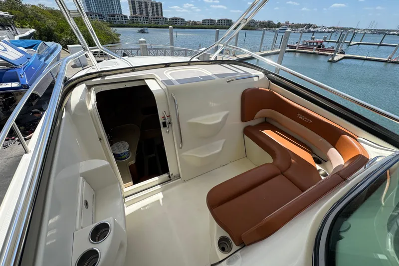 Slide: The Image of 2006 Hydra-Sports Vector 3300 VX boat interior with brown seating, docked by the water. - 20