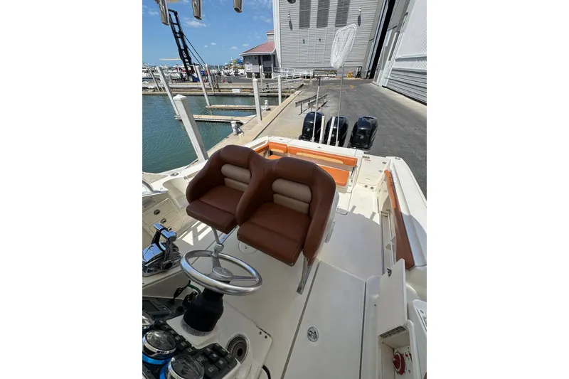 Slide: The Image of 2006 Hydra-Sports Vector 3300 VX boat interior with brown seating at a marina. - 30