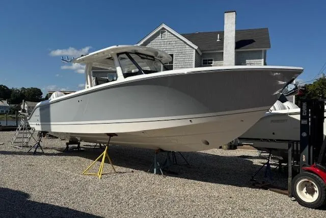 The Image of 2026 Pursuit S 328 Sport boat on display outdoors, near a house. - 0