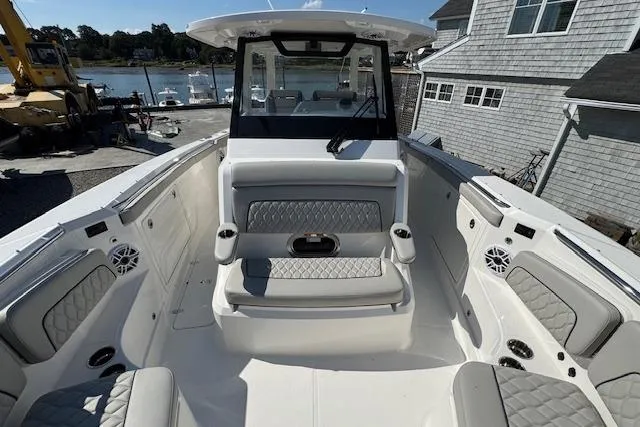 Slide: The Image of 2026 Pursuit S 328 Sport boat interior with cushioned seating and waterfront view. - 26