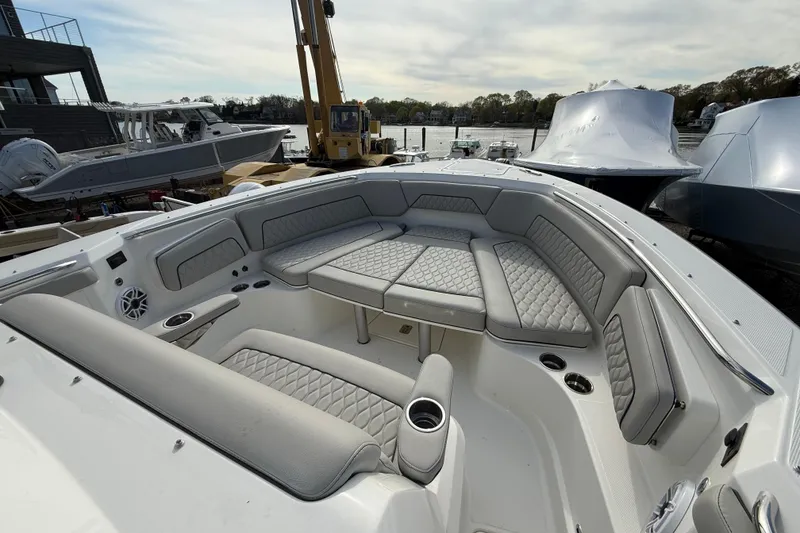 Slide: The Image of 2026 Pursuit S 328 Sport boat with luxurious seating and modern design at a marina. - 27