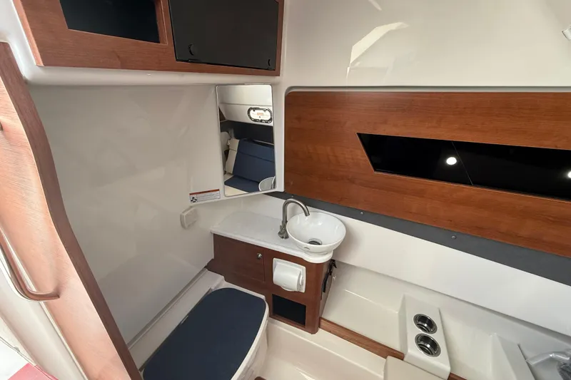 Slide: The Image of Interior of 2026 Pursuit S 328 Sport boat with modern wood accents and compact sink. - 34
