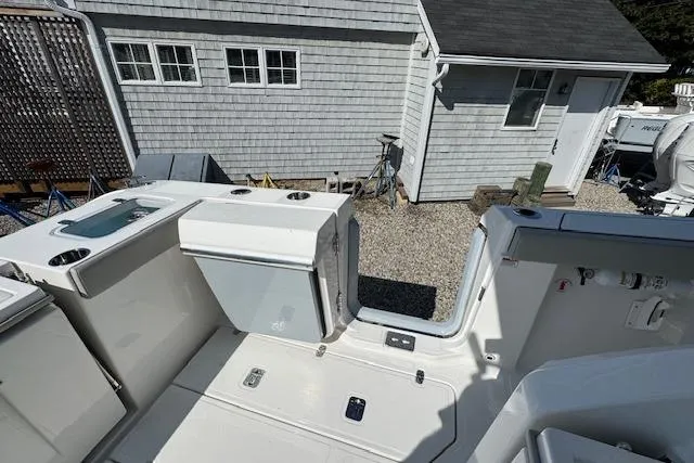 Slide: The Image of 2026 Pursuit S 328 Sport boat interior with storage compartments, near a house. - 6