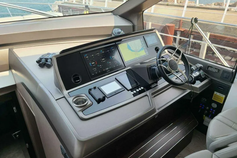 Slide: The Image of 2023 Sunseeker Manhattan 68 yacht helm with advanced navigation systems and controls. - 17