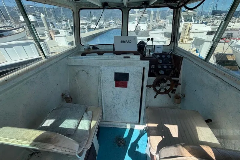 Slide: The Image of Interior of a 1976 Wilson 24 boat with steering wheel and navigation equipment. - 11