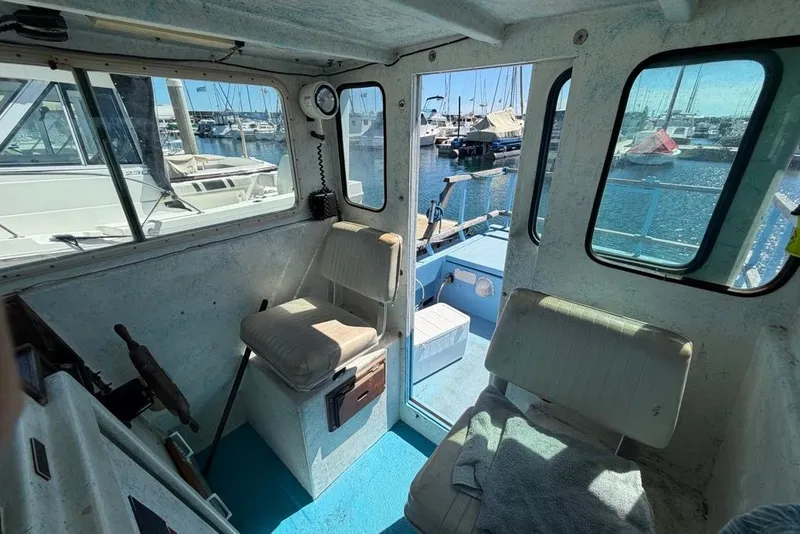 Slide: The Image of Interior of a 1976 Wilson 24 boat with marina view through windows. - 12