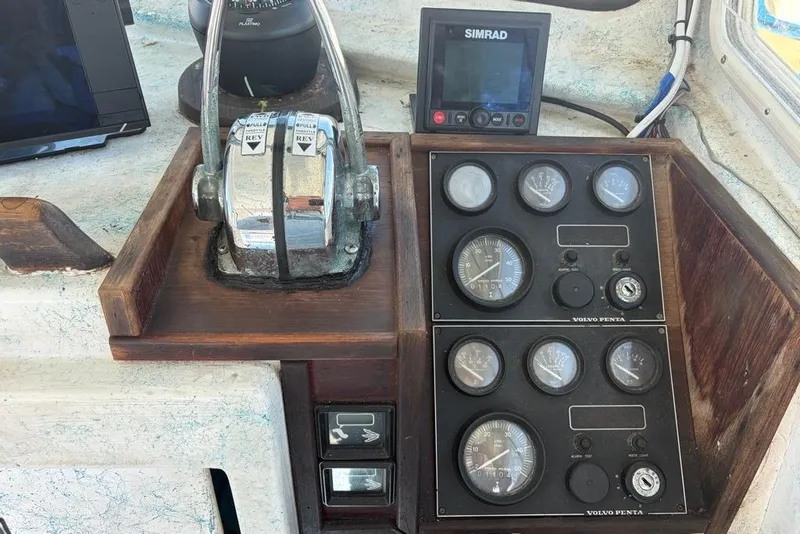 Slide: The Image of 1976 Wilson 24 boat control panel with gauges and Simrad display. - 13