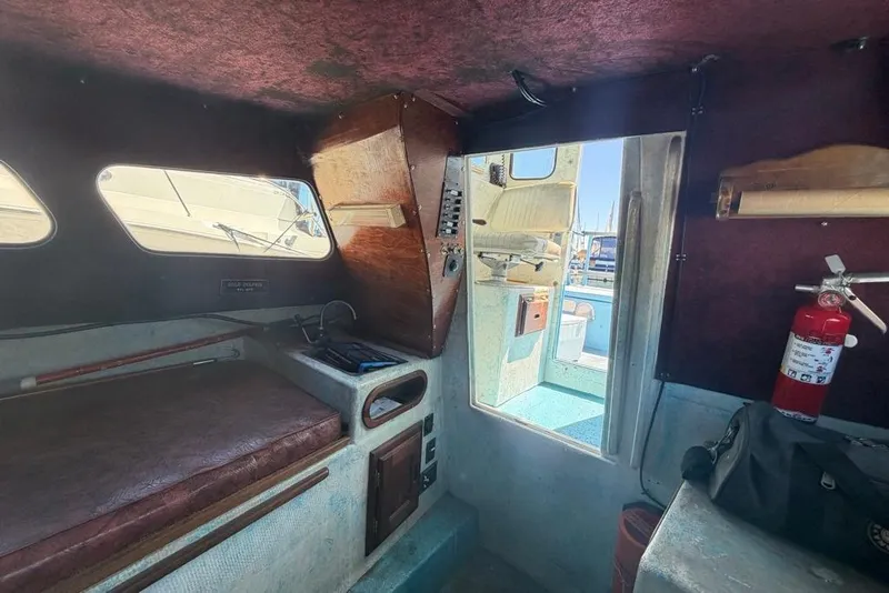 Slide: The Image of Interior of a 1976 Wilson 24 boat with seating, windows, and a fire extinguisher. - 15