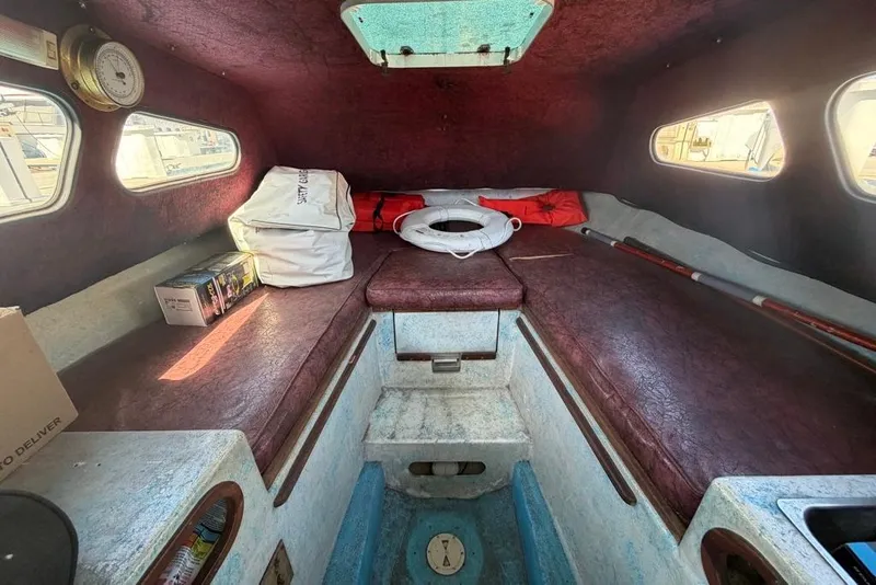 Slide: The Image of Interior of a 1976 Wilson 24 boat cabin with seating and storage. - 16