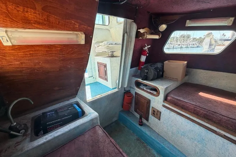 Slide: The Image of Interior of a 1976 Wilson 24 boat with seating, storage, and a window view. - 17