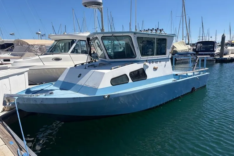 Slide: The Image of 1976 Wilson 24 boat docked in a marina, surrounded by other vessels. - 3