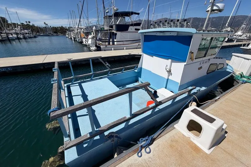 Slide: The Image of 1976 Wilson 24 boat docked at marina, surrounded by other vessels. - 5