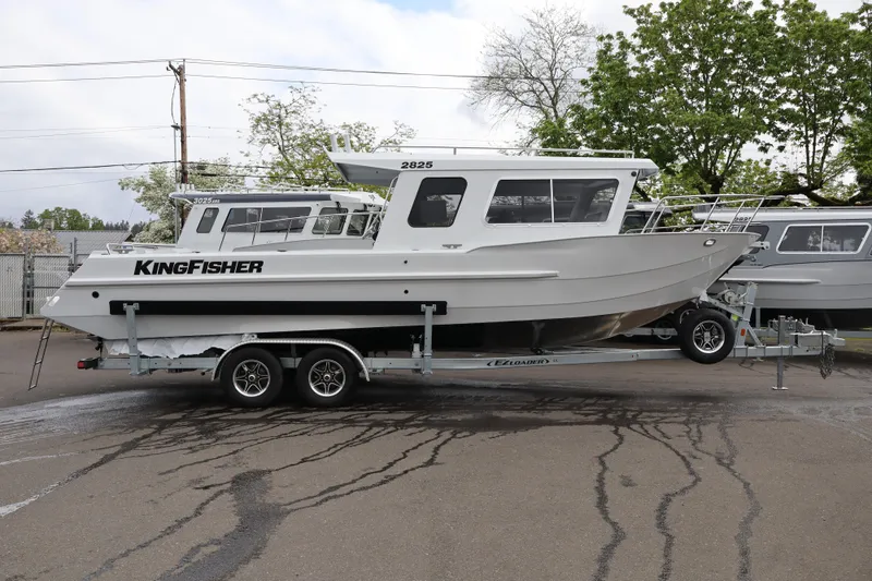 The Image of 2026 KingFisher 2825 Coastal Express boat on trailer, parked outdoors. - 1