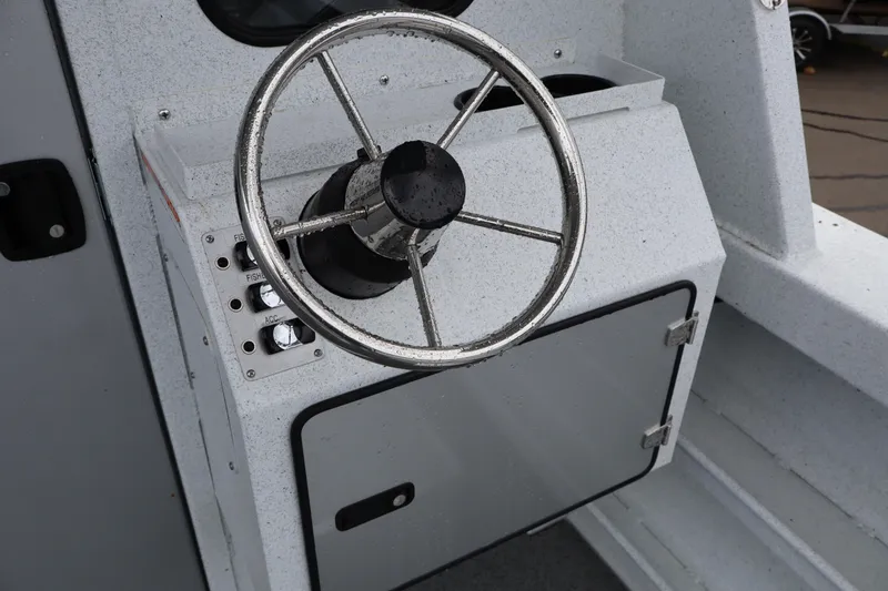 Slide: The Image of Steering wheel of 2026 KingFisher 2825 Coastal Express boat, featuring control panel and storage compartment. - 13