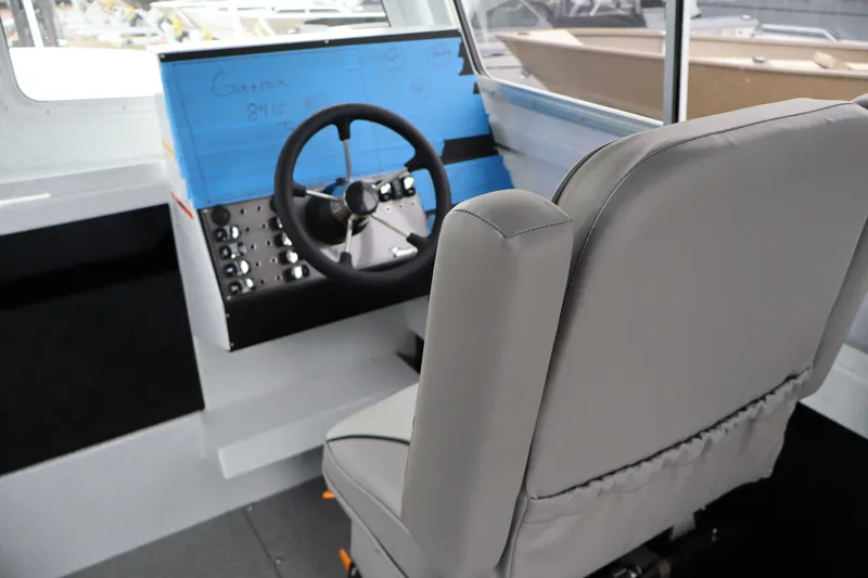 Slide: The Image of Interior helm of 2026 KingFisher 2825 Coastal Express boat with steering wheel and controls. - 15
