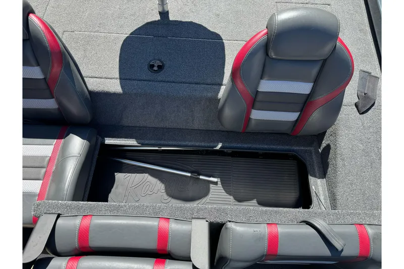 Slide: The Image of 2024 Ranger RT178 boat interior with gray and red seats, storage compartment open. - 24