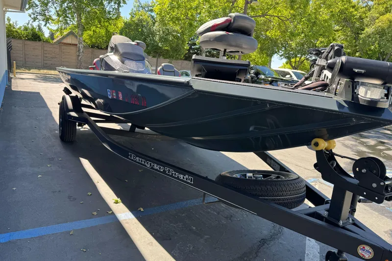 Slide: The Image of 2024 Ranger RT178 boat on trailer, parked outdoors under trees. - 7