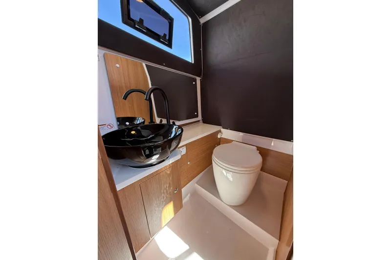 Slide: The Image of Modern yacht bathroom with sleek black sink and compact toilet, VIRTUE YACHTS V10 TOP 2026. - 16