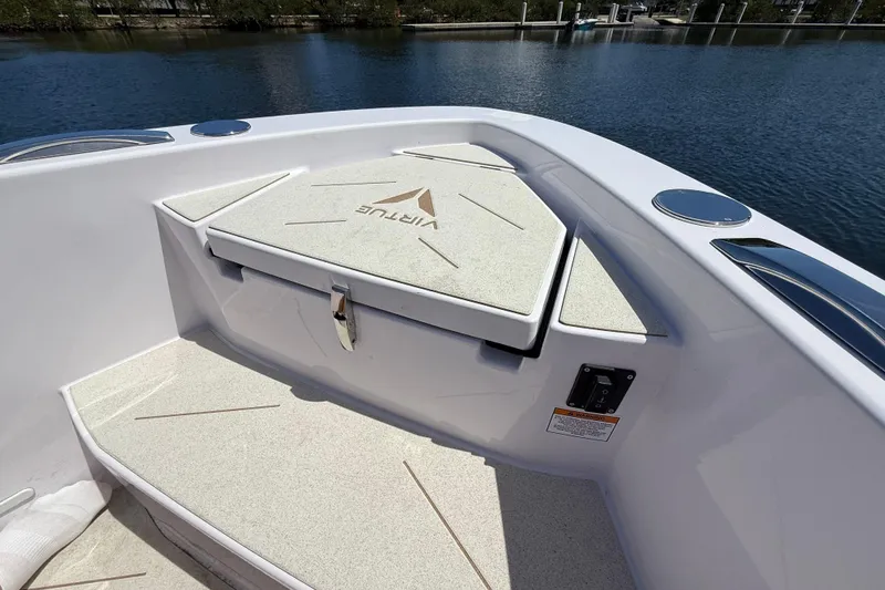 Slide: The Image of 2026 VIRTUE YACHTS V10 TOP deck detail with storage compartment, docked by calm waters. - 19