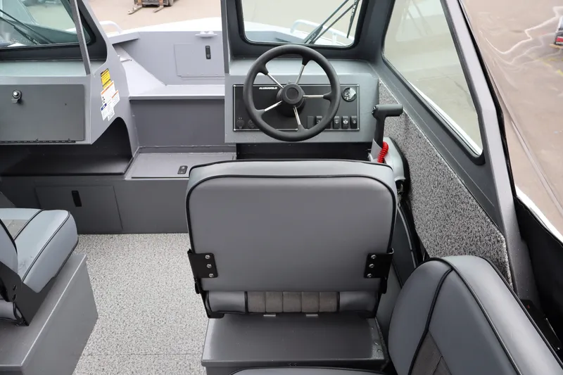 Slide: The Image of Interior of 2026 Alumaweld Stryker X202 boat, featuring steering wheel and seating. - 10