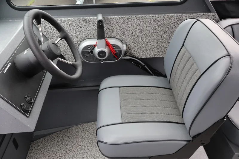 Slide: The Image of Interior of 2026 Alumaweld Stryker X202 boat, featuring steering wheel and cushioned seat. - 13