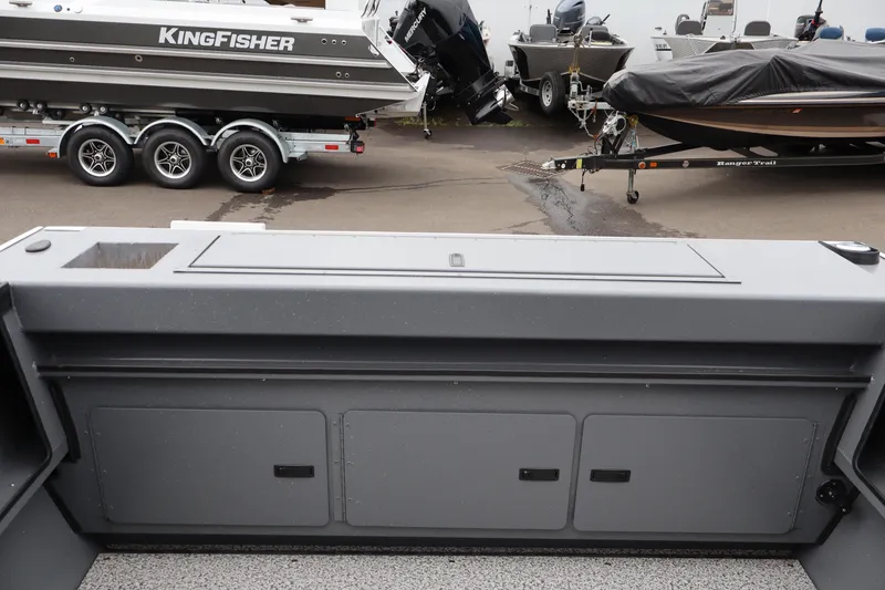 Slide: The Image of 2026 Alumaweld Stryker X202 boat interior with storage compartments, parked near other boats. - 5