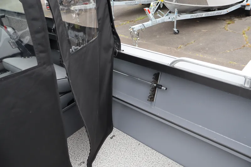 Slide: The Image of Interior view of 2026 Alumaweld Stryker X202 boat with protective cover and trailer in background. - 8