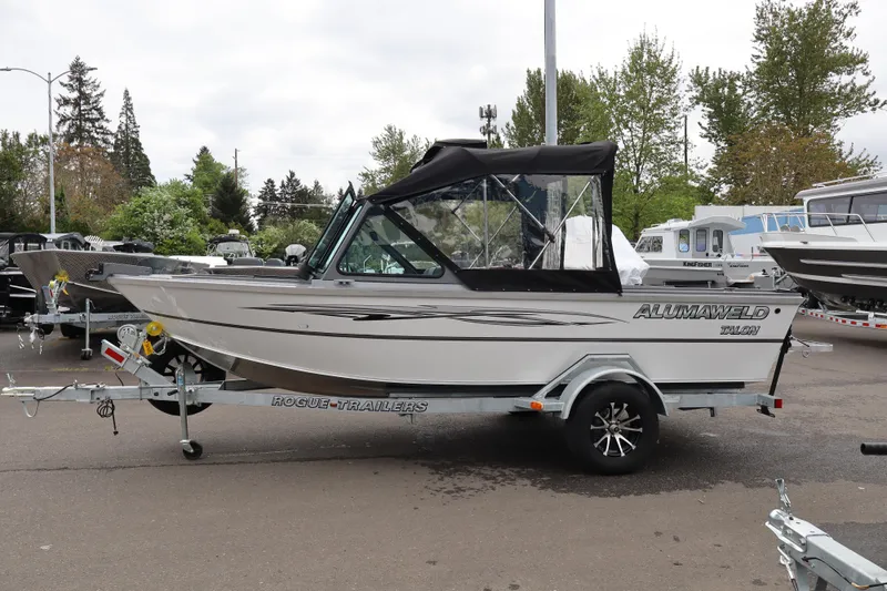 The Image of 2026 Alumaweld Talon 18 boat on trailer, parked outdoors with trees in background. - 1