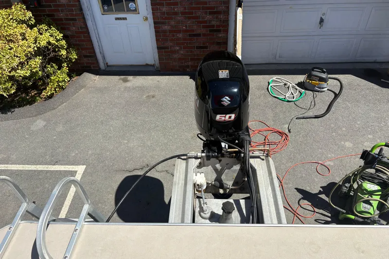 Slide: The Image of 2011 Sun Tracker Bass Buggy 18 Classic Series with Suzuki 50 outboard motor in driveway. - 3