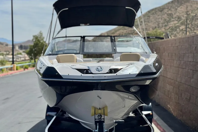 Slide: The Image of 2017 Scarab 255 H.O. Platinum boat on trailer, parked near a brick wall. - 2