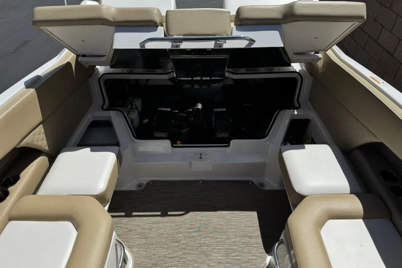 Slide: The Image of 2017 Scarab 255 H.O. Platinum boat interior with beige seating and open storage compartment. - 21