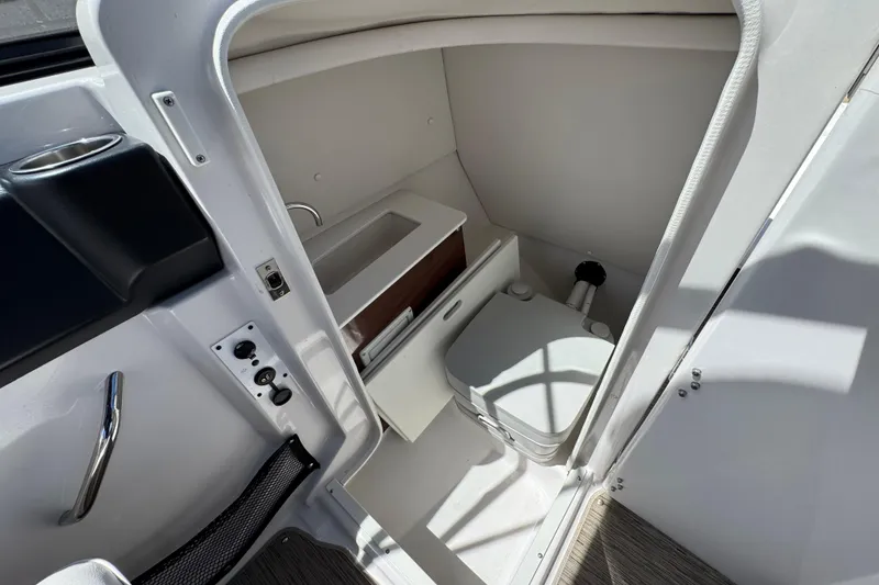 Slide: The Image of Interior of 2017 Scarab 255 H.O. Platinum boat featuring compact bathroom amenities. - 29