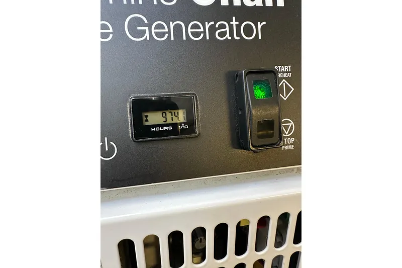 Slide: The Image of Onan marine generator control panel with hour meter reading 974 hours, aboard 2011 Beneteau Monte Carlo 47 Fly. - 49
