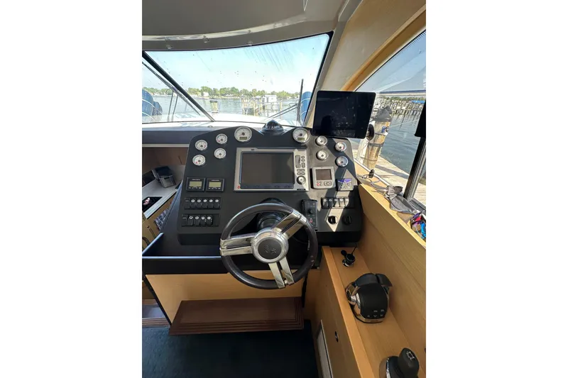 Slide: The Image of Helm of 2011 Beneteau Monte Carlo 47 Fly, featuring modern navigation instruments and steering wheel. - 20