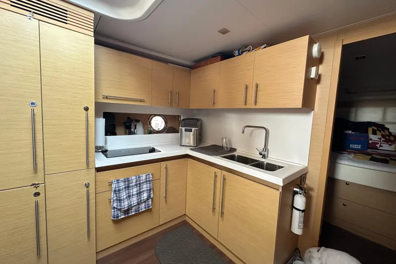 Slide: The Image of Modern kitchen interior of 2011 Beneteau Monte Carlo 47 Fly yacht, featuring wood cabinetry and dual sinks. - 31