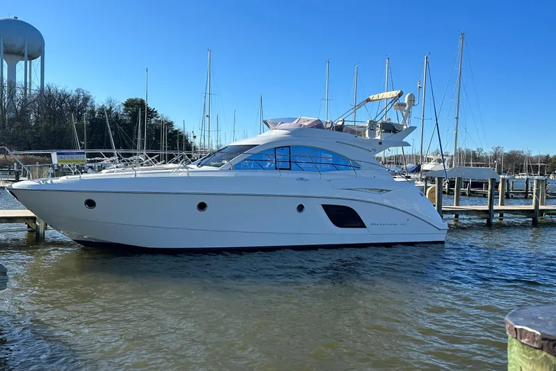 Slide: The Image of 2011 Beneteau Monte Carlo 47 Fly yacht docked at marina, clear blue sky. - 6