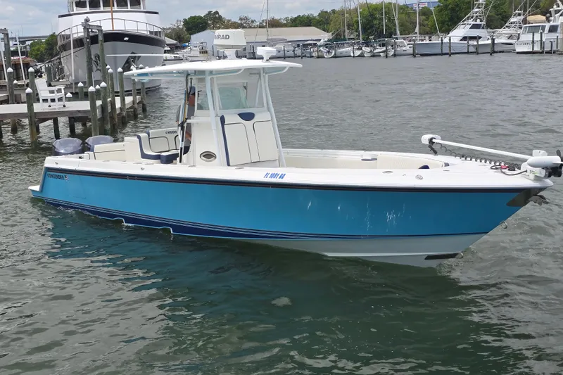 The Image of 2012 Contender 32 LS boat in marina, blue hull, calm water. - 0