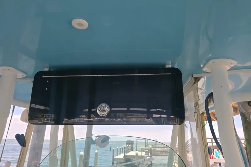 Slide: The Image of 2012 Contender 32 LS boat interior with blue ceiling and storage compartment. - 12