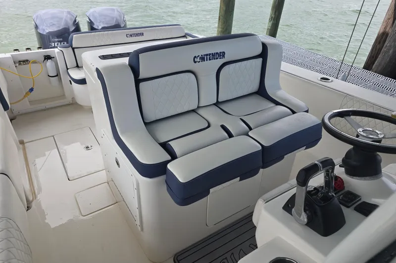 Slide: The Image of 2012 Contender 32 LS boat interior with cushioned seating and steering wheel. - 13