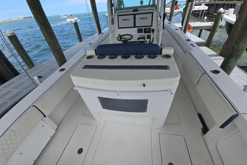 Slide: The Image of 2012 Contender 32 LS boat interior with helm and seating, docked by the water. - 15