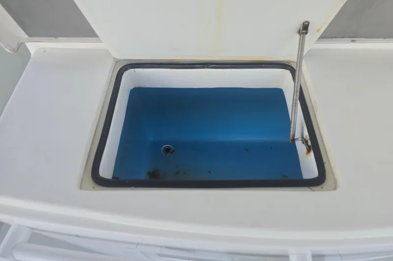 Slide: The Image of Open storage compartment on 2012 Contender 32 LS boat, featuring a blue interior. - 17