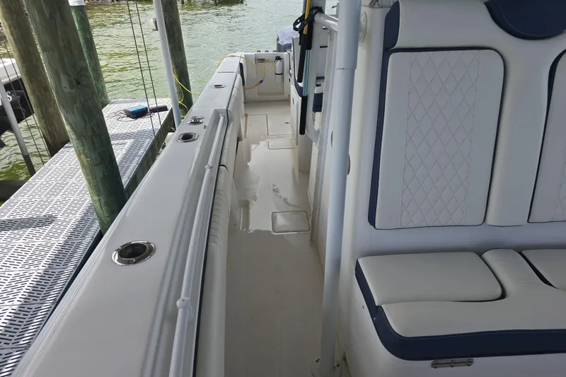 Slide: The Image of 2012 Contender 32 LS boat interior with white cushioned seating and dockside view. - 18