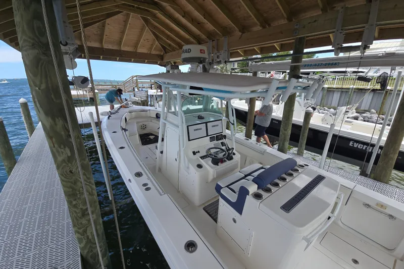 Slide: The Image of 2012 Contender 32 LS boat docked under a wooden shelter. - 24