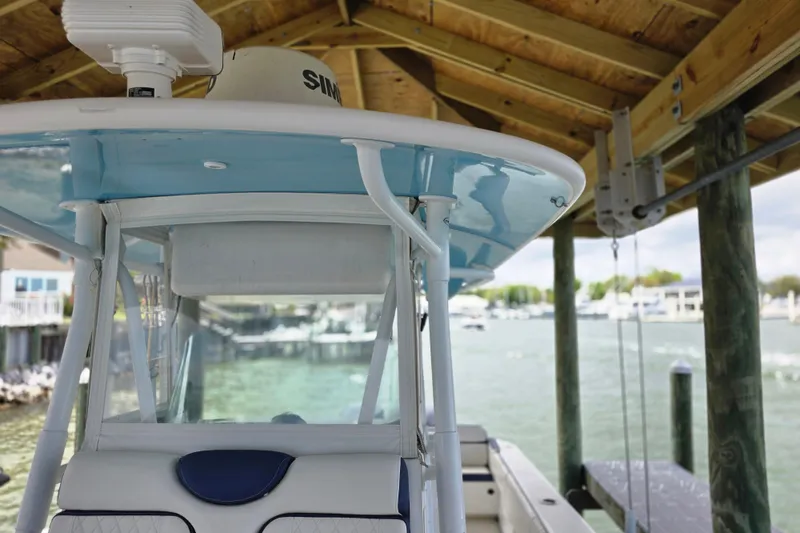 Slide: The Image of 2012 Contender 32 LS boat docked under wooden shelter by the water. - 25