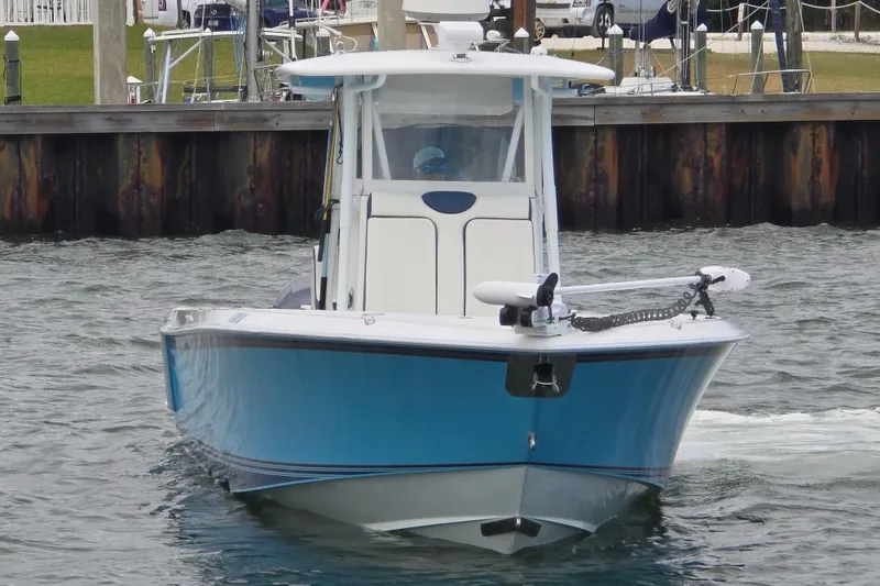 Slide: The Image of 2012 Contender 32 LS boat in blue, navigating near a dock. - 4
