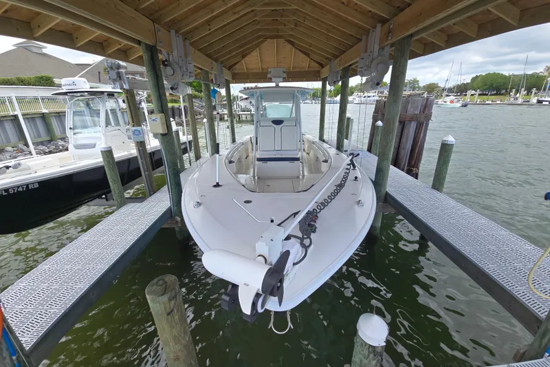 Slide: The Image of 2012 Contender 32 LS boat docked under a wooden shelter at a marina. - 7
